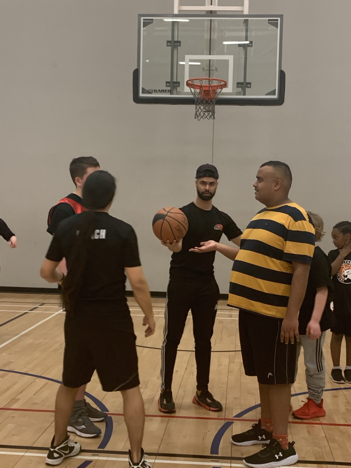 Buddies gathered around a basketball in a gym