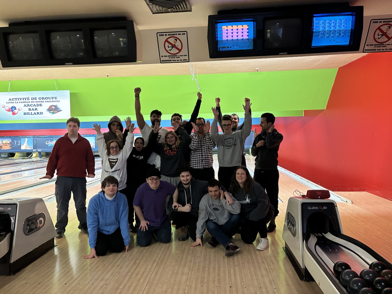 Buddies celebrating together beside the bowling lanes