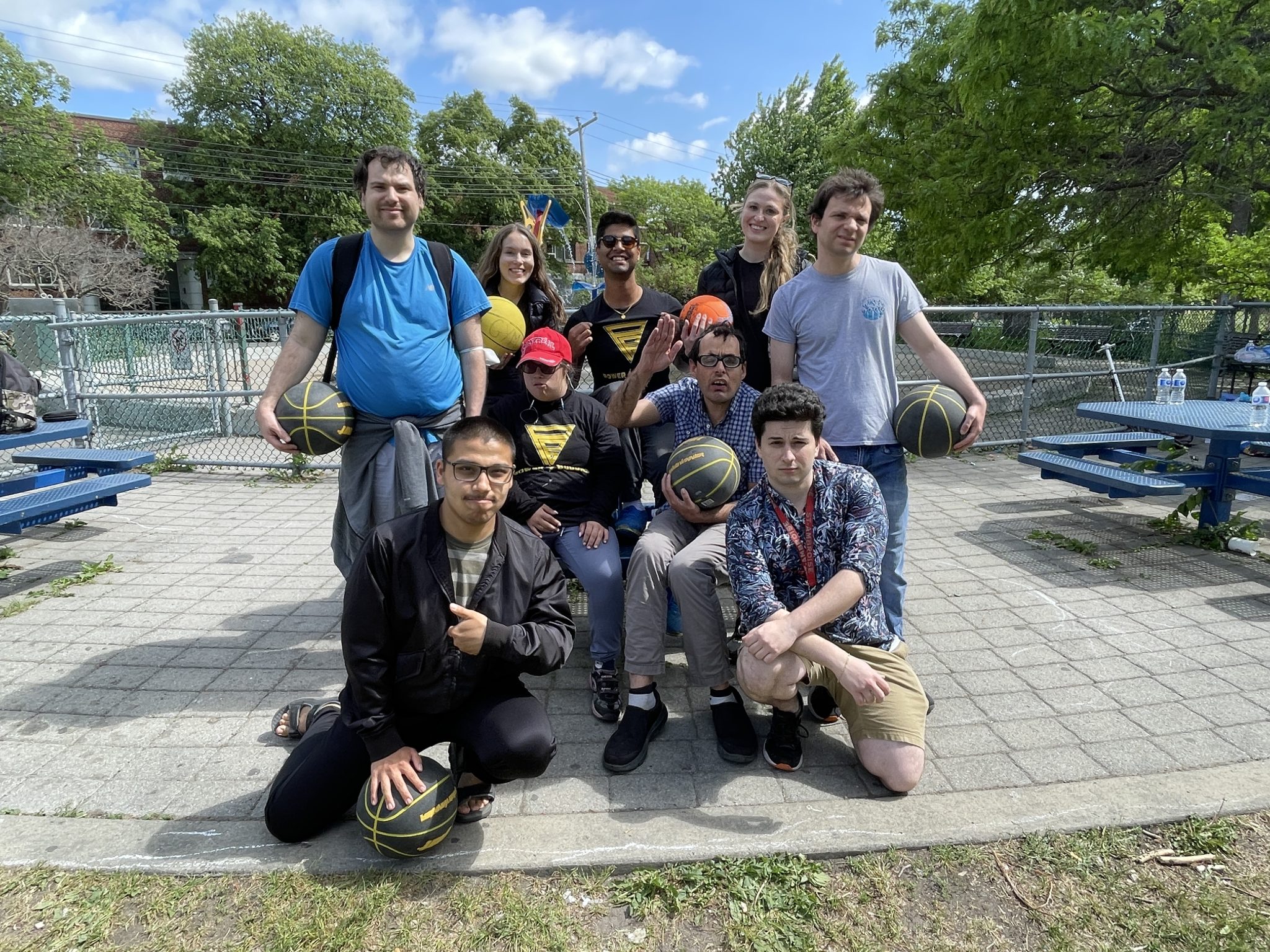 Power Buddies participants, buddies and volunteers posing with basketballs after an outdoor activity